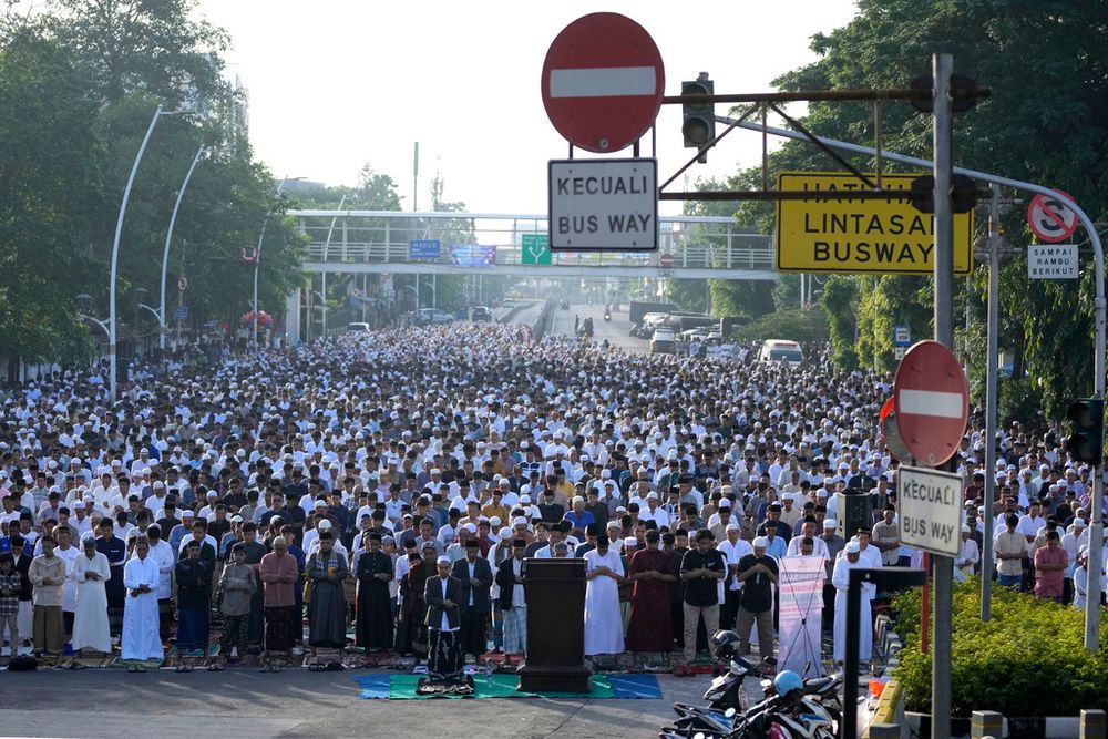 Muslim men perform an Eid al-Fitr prayer marking the end of the holy fasting month of Ramadan on a street in Jakarta, Indonesia.