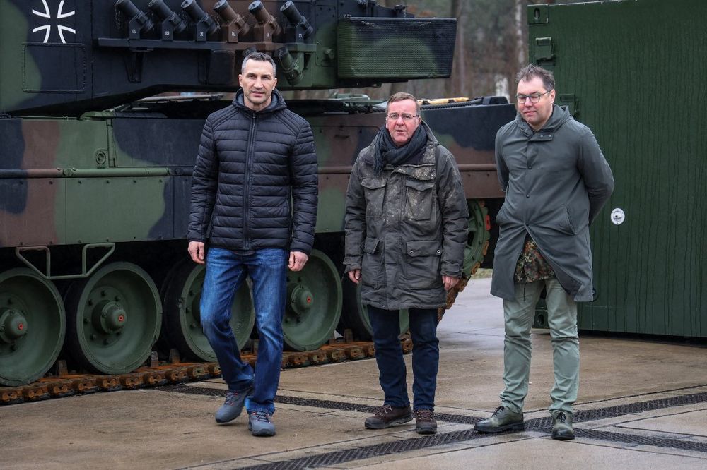 German Defense Minister Boris Pistorius (C), Ukraine's ambassador to Germany Oleksii Makeiev, and Ukrainian former boxer Wladimir Klitschko (L) stand in front of a Leopard 2A6 tank at the Armored Corps Training Centre in Munster, northern Germany.