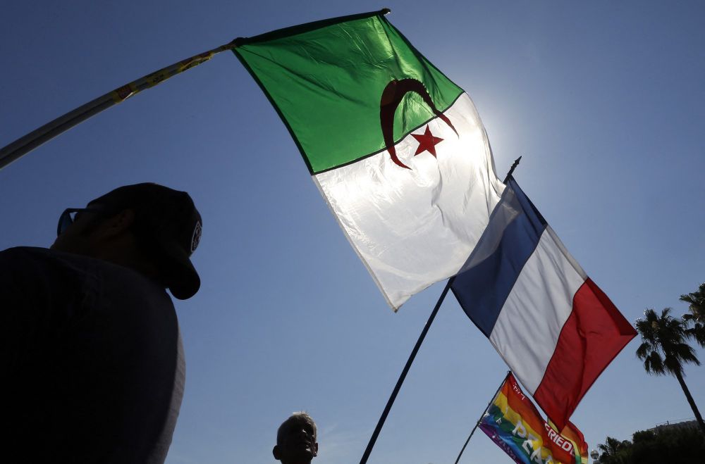People wave the French and Algerian flags on July 05, 2014, in Nice, southeastern France.
