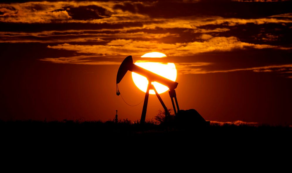 Le soleil se couche derrière un puit de pétrole