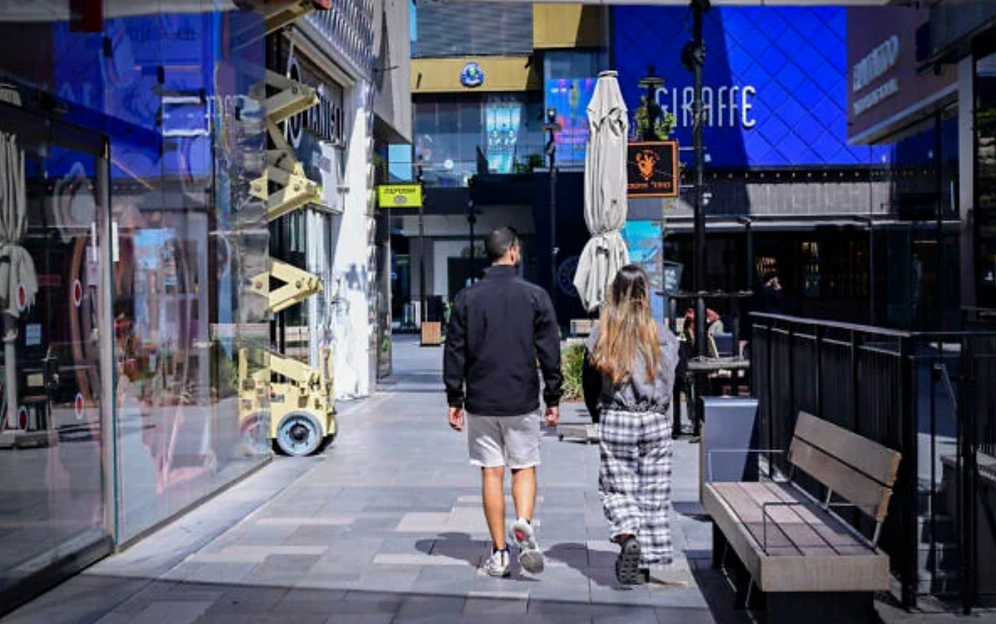 Des personnes passent devant le centre commercial BIG Fashion Glilot fermé, dans le centre d’Israël, le 5 mars 2026.