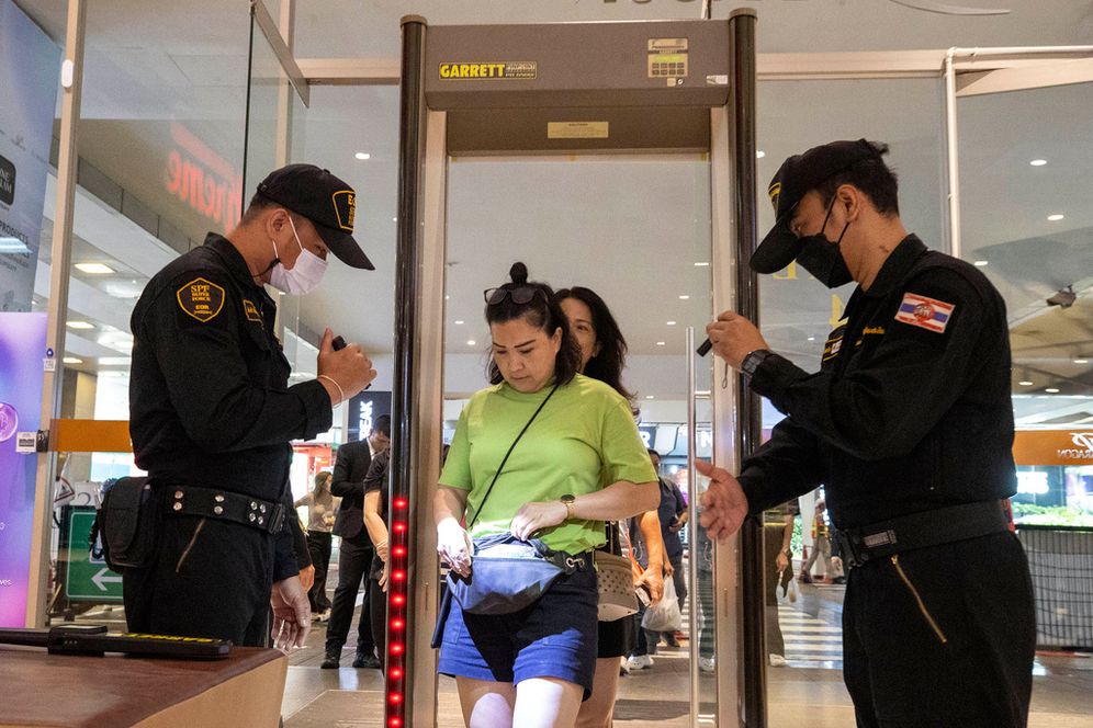 Security guards check a visitor's bag before allowing them into the Siam Paragon Mall in Bangkok, Thailand