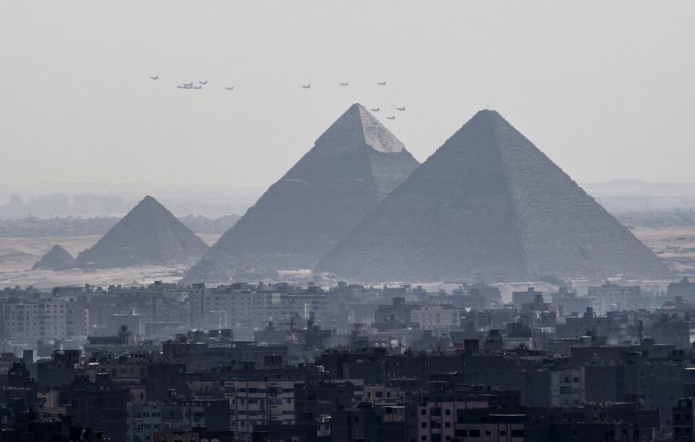 ثلاث طائرات رافال مقاتلة فرنسية الصنع (في المقدمة) تحلق مع طائرات حربية مصرية أخرى فوق أهرامات الجيزة، على مشارف القاهرة، في 21 يوليو/تموز 2015. 