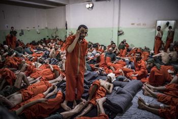 This file photo taken on October 26, 2019, shows men suspected of Islamic State (IS) ties, gathered in a cell of the Sinaa prison in the Ghwayran neighbourhood in Hasakeh, Syria.