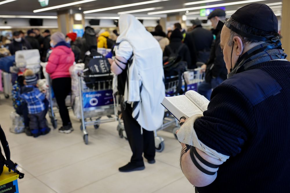 A Jewish Ukrainian man who fled a war zone in Ukraine covered in a prayer shawl and prays, at the Chisinau International Airport in Moldova, as he makes his way to Israel, March 6, 2022.