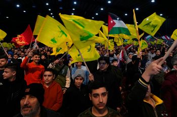 Supporters of the Iranian-backed Hezbollah group wave Hezbollah and Palestinian flags, in Lebanon.