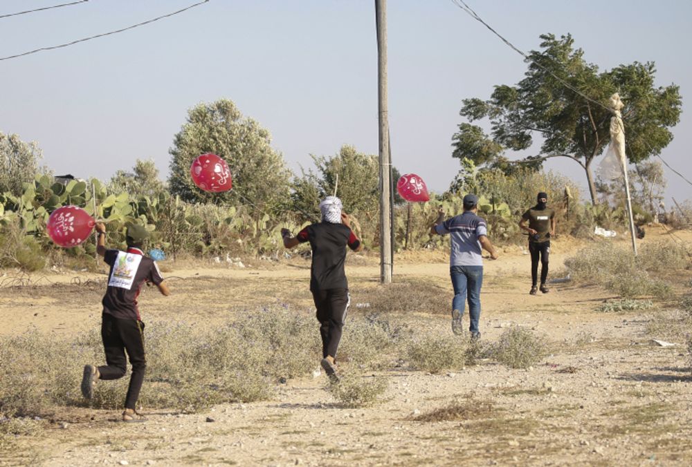 Palestinian terrorists in Gaza prepare to release balloon-borne explosive and incendiary devices towards Israel, along the Israel-Gaza border, on August 21, 2020.