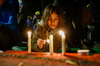 Kids light candles in memory of the seven victims of the Neve Ya'akov terror attack during protest against the proposed changes to the legal system, outside the president's residence in Jerusalem.