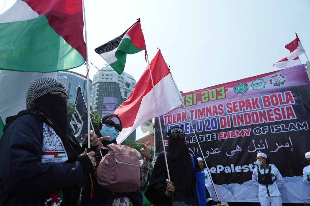 Protesters wave Palestinian flags during a protest in Jakarta, Indonesia.
