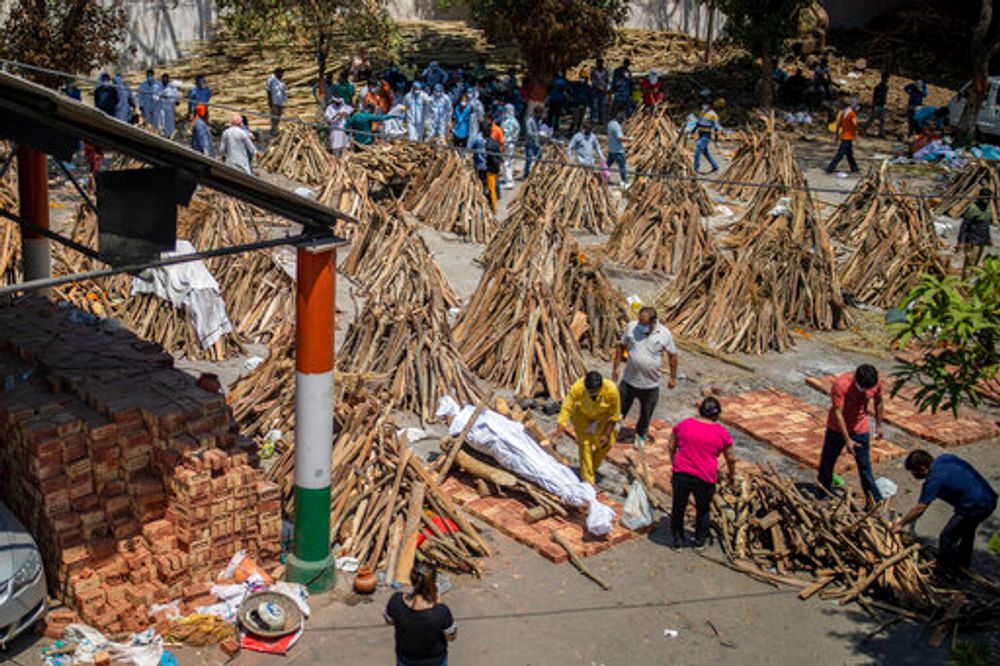 People prepare a funeral pyre for a family member who died of COVID-19 at a ground that has been converted into a crematorium for mass cremation of COVID-19 victims in New Delhi, India, on April 24, 2021.