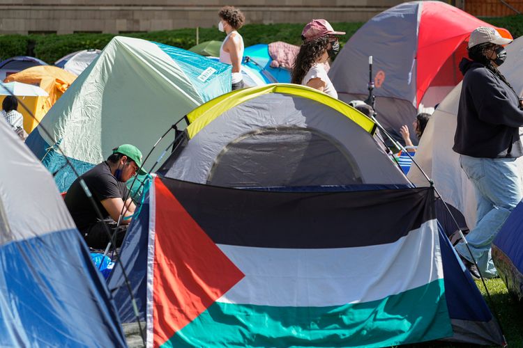 A Palestinian flag is displayed outside a tent at an encampment on the UCLA campus.