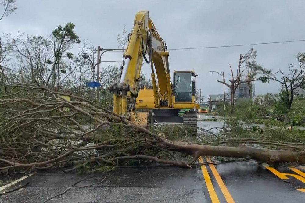 This screen grab taken from AFPTV footage shows a worker clearing fallen trees from a road in the aftermath of Typhoon Haikui in Taitung County.