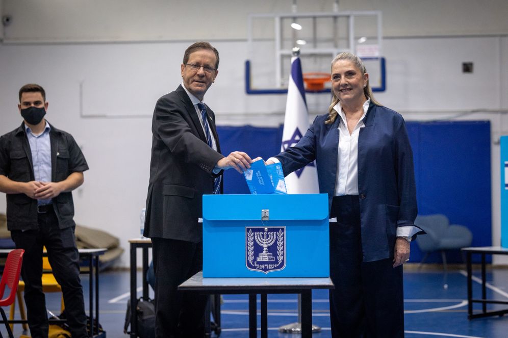 Photo by Yonatan Sindel/FLASH90 Israeli president Isaac Herzog and his wife Michal cast their ballots at a polling station in Jerusalem, during Election Day in Israel, October 27, 2026.