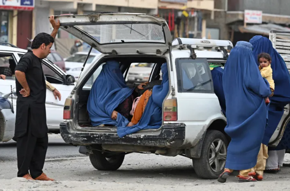 Des femmes portant une burqa entrent dans un taxi à Kaboul le 31 juillet 2021.