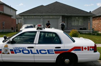 AP Photo/The Canadian Press, Dave Chidley RCMP investigators walk be in to the house as they work to remove evidence boxes from a home in London, Ontario, Thursday, Aug. 26, 2010.