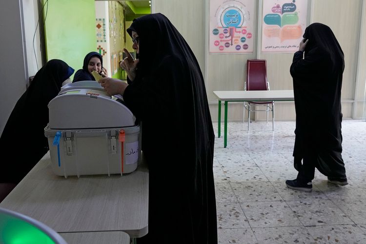 An Iranian woman votes for the parliamentary runoff elections at a polling station in Tehran, Iran, May 10, 2024.