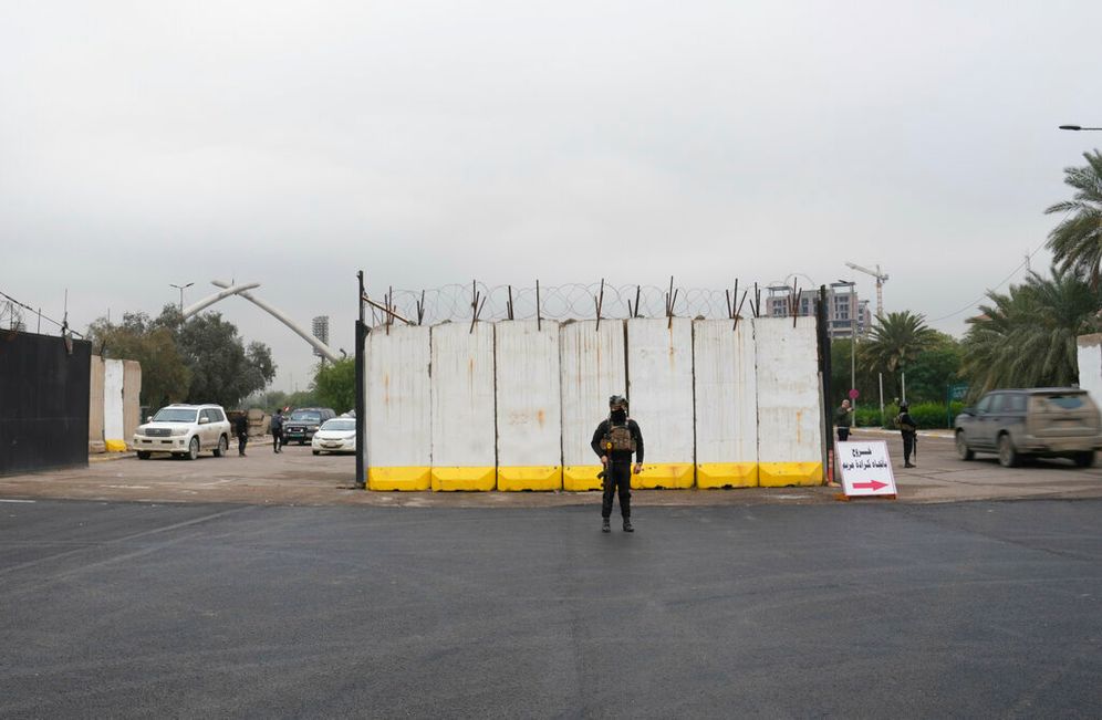 Iraqi security forces stand guard as they check motorists entering the Green Zone, in Baghdad, Iraq.