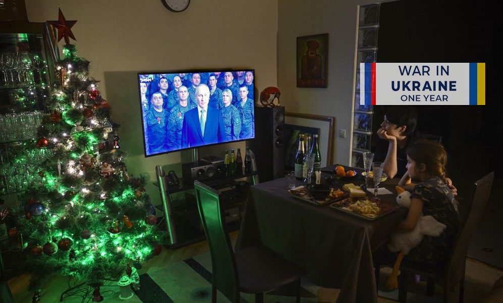 Alexander NEMENOV / AFP A family watches a TV address of Russian President Vladimir Putin for the New Year in Moscow, Russia.