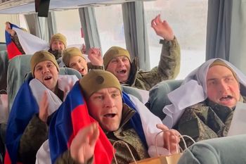 In this image made from video provided by Russian Defense Ministry Press Service on Thursday, Feb. 5, 2026, Russian servicemen with Russian national flags react in a bus after returning from captivity during a POWs exchange of a group of servicemen between Russia and Ukraine at an undisclosed location in Belarus.