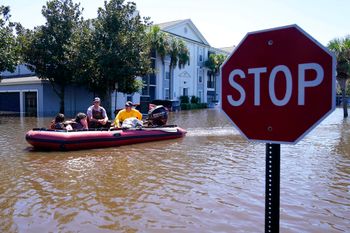 People evacuate after an apartment complex was totally flooded by rain from Hurricane Ian in Florida, the United States, on September 30, 2022.