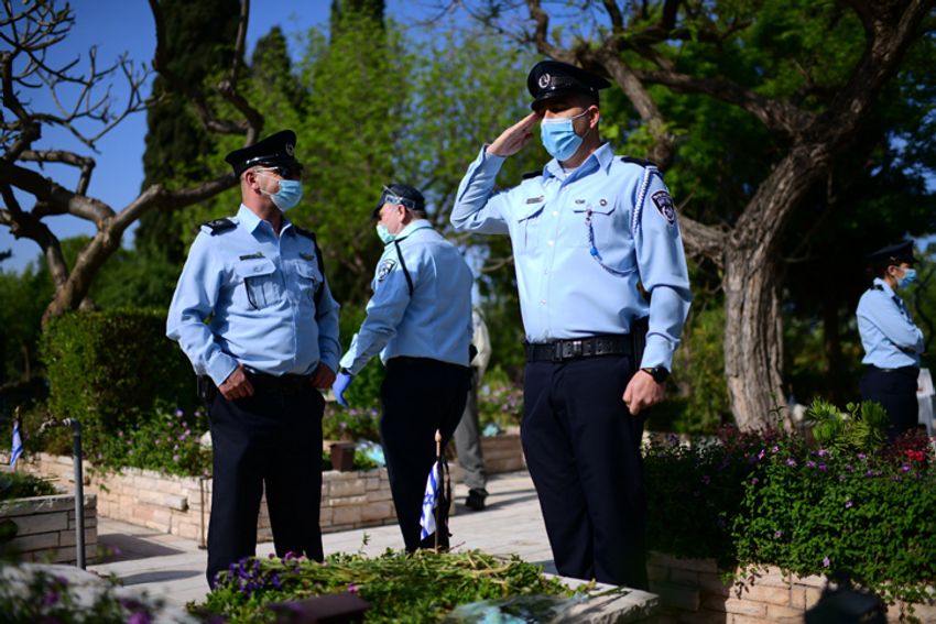 Des policiers israéliens se recueillant sur les tombes des soldats tombés au combat au cimetière de Givat Shaul, le 27 avril 2020.