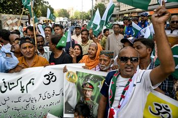 متظاهرون يحملون لافتة عليها صورة رئيس أركان الجيش الباكستاني، الفريق أول سيد عاصم منير، إلى جانب لافتات عليها الرمز الهندوسي المقدس "أوم"، خلال احتجاج مناهض للهند في كراتشي، 10 مايو/أيار 2025. ، 