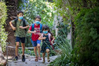 Israeli kids wearing school bags and face masks ahead of the first day of school and kindergarten outside their home in Jerusalem, on August 31, 2020.