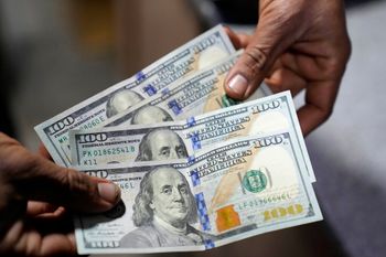 A money trader shows U.S. 100 dollar notes at a currency exchange office in Lahore, Pakistan.