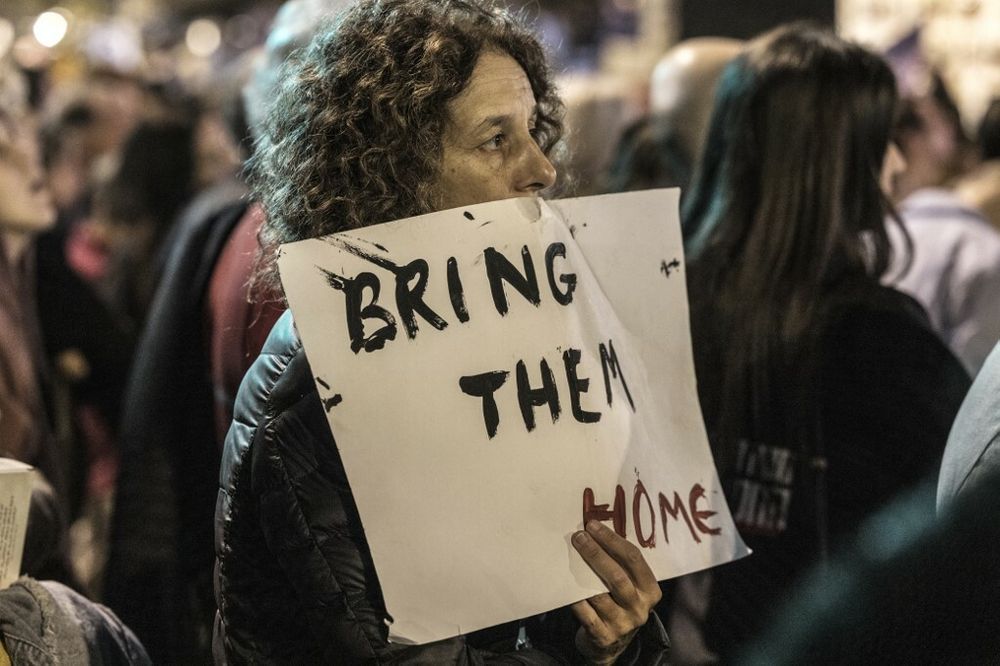 A woman holds a banner reading “Bring them home” during a demonstration calling for the release of Israeli hostages, outside the Tel Aviv Museum of Art, now informally called the “Hostages Square” in Israel.