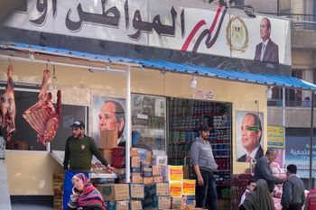 عملاء يشترون البقالة من متجر ترعاه الحكومة ويواجه ملصقات الرئيس المصري عبد الفتاح السيسي في القاهرة، مصر، الاثنين، 27 فبراير 2023.