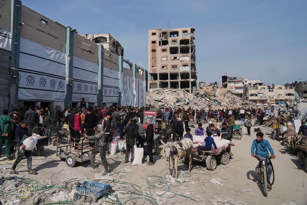 Palestinians receive bags of flour and other humanitarian aid distributed by UNRWA, the UN agency helping Palestinian refugees in Jabaliya, Gaza Strip
