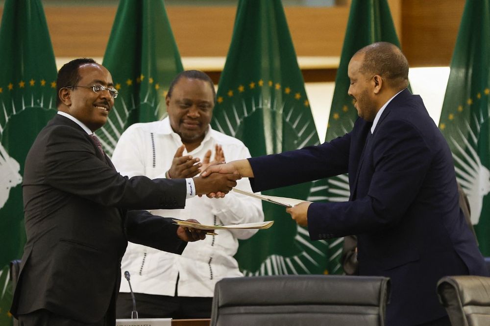 Redwan Hussien Rameto (L), representative of the Ethiopian government, and Getachew Reda (R), representative of the Tigray People's Liberation Front, shake hands on a peace agreement between the two parties in Pretoria, South Africa, on November 2, 2022.