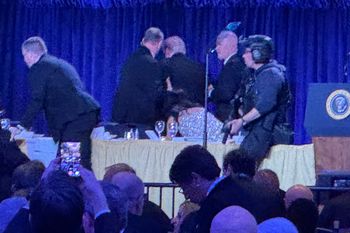 U.S. Secret Service agents surround President Donald Trump, third from left, as he is taken from the stage after a shooting incident outside the ballroom during the White House Correspondents Dinner, Saturday, April 25, 2026, in Washington.