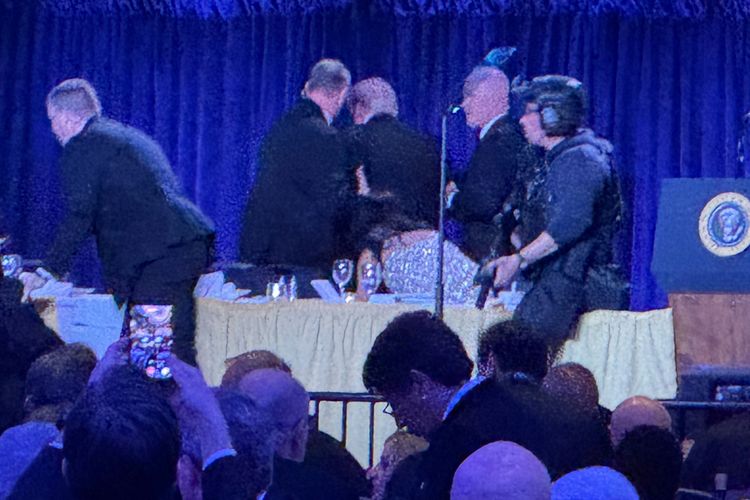 U.S. Secret Service agents surround President Donald Trump, third from left, as he is taken from the stage after a shooting incident outside the ballroom during the White House Correspondents Dinner, Saturday, April 25, 2026, in Washington.