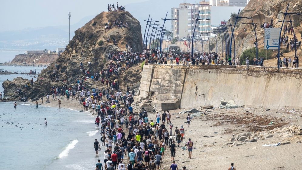 AP אנשים הולכים על חוף הים לאחר שניסו לחצות את הכביש מהעיירה פנידק בצפון מרוקו למובלעת הספרדית סאוטה, יום שישי, 31 ביולי 2026
