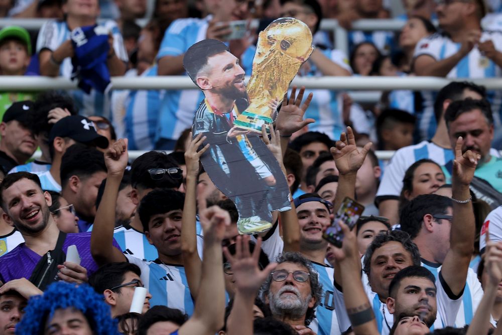 Argentina soccer fans hold a cardboard cutout with the image of soccer star Lionel Messi with the FIFA World Cup trophy as they wait for the start of an international friendly soccer match between Argentina and Curacao in Santiago del Estero, Argentina.