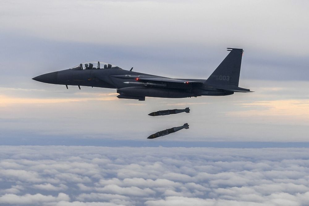 Un F-15K de l'armée de l'air sud-coréenne larguant deux bombes à guidage de précision JDAM sur une cible au champ de tir de Jikdo en mer Jaune
