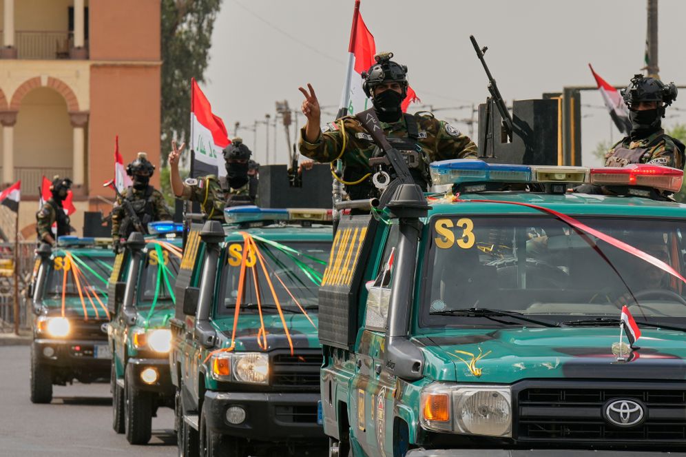 Iraqi security officers flash victory signs as they ride on vehicles decorated with national flags and ribbons during a convoy celebrating the complete withdrawal of U.S. troops from Iraq, in Baghdad, Iraq, Wednesday, Sept. 30, 2026