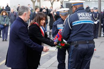La maire de Paris Anne Hidalgo remet une gerbe de fleurs aux policiers lors d'une cérémonie marquant le huitième anniversaire de l'attentat jihadiste du magazine satirique Charlie Hebdo, le 7 janvier 2023.