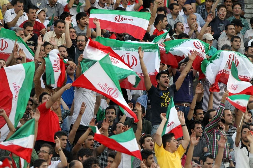 Iranian football fans wave the national flag