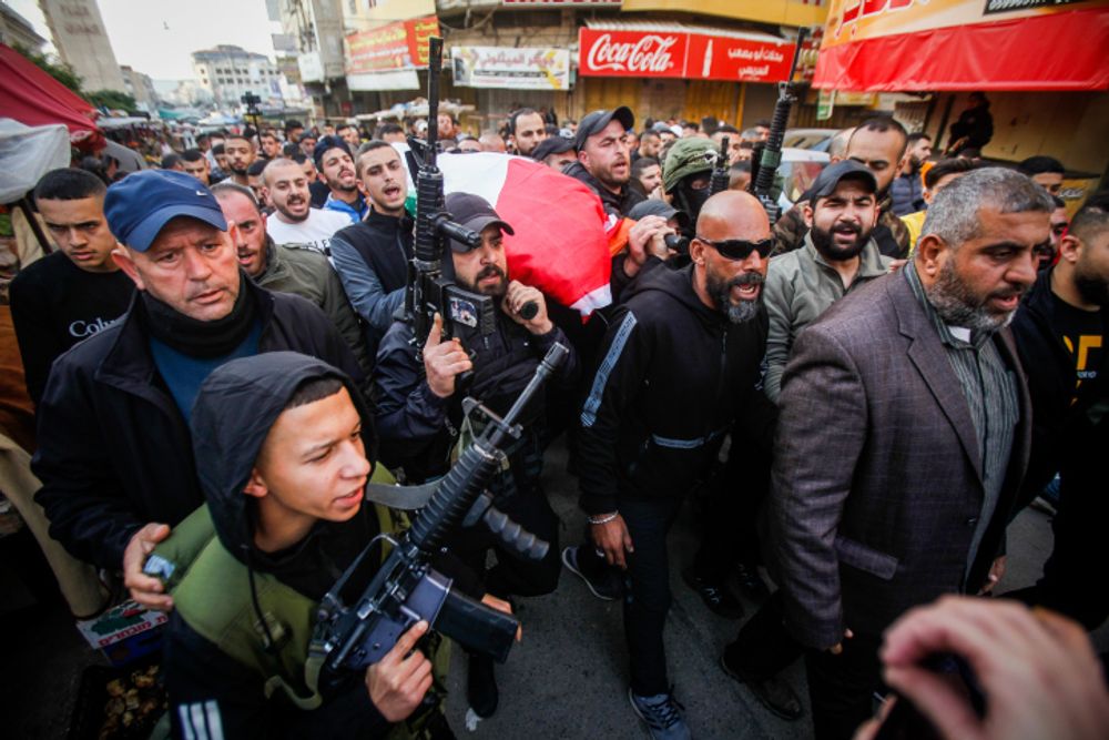 Palestinian gunmen and mourners attend the funeral of 16-year-old Palestinian Jana Zakarneh, killed during an Israeli army raid, in the West Bank city Jenin, December 12, 2022.