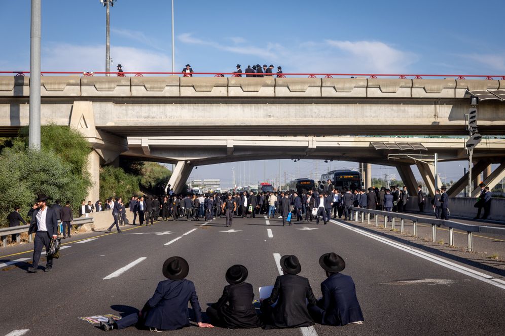 Ultra orthoodx jewish men block a road and clash with police during a protest against the jailing of yeshiva students who failed to comply with an army recruitment order, at Ganot junction junction, June 11, 2026