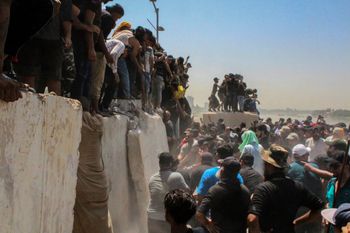 Des manifestants tentent de retirer des barrières en béton et de traverser le pont en direction de la zone verte à Bagdad, en Irak, le 30 juillet 2022