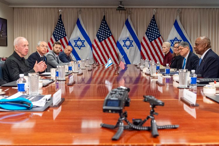Israeli Defense Minister Yoav Gallant, at far left, speaks while meeting with Defense Secretary Lloyd Austin, across table at far right, at the Pentagon.