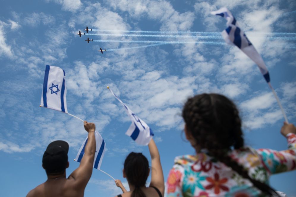 People at Bugrashov Beach in Tel Aviv watch the military airshow on Israel's 71st Independence Day on May 9, 2019