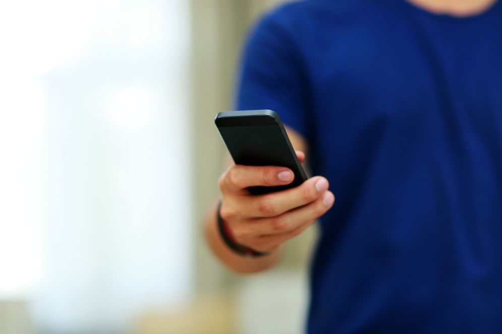 גבר מחזיק סמארטפון, אילוסטרציה (למצולם אין קשר לנאמר בכתבה)