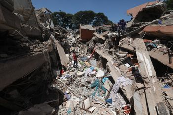 Rescues workers and residents search through the rubble after an earthquake struck Cali, Colombia, Monday, Aug. 10, 2026. 