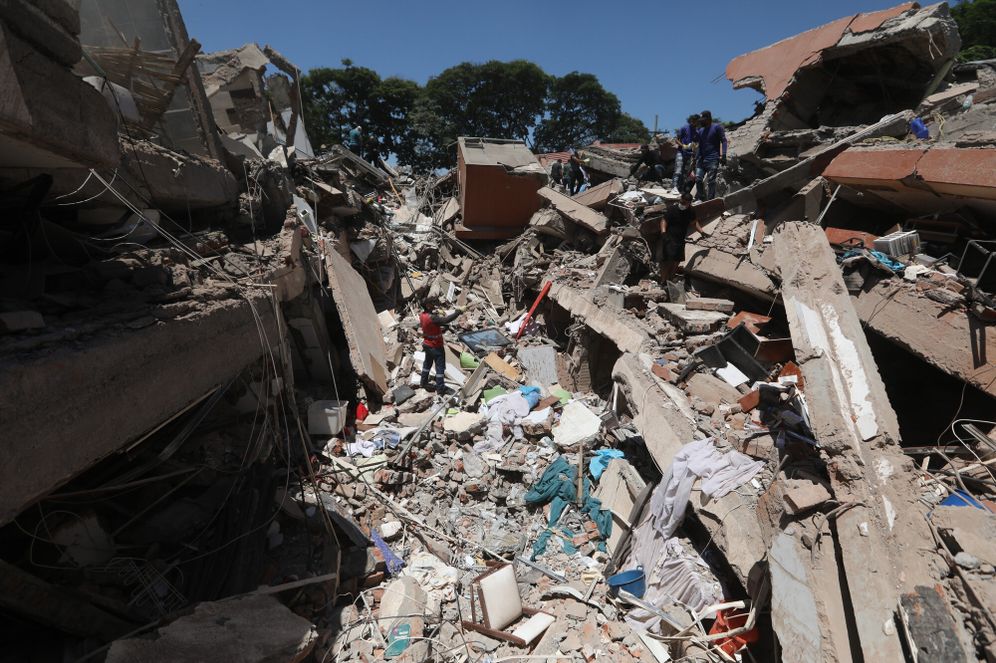 (AP Photo/Santiago Saldarriaga) Les secouristes et les habitants fouillent les décombres après le tremblement de terre qui a frappé Cali, en Colombie