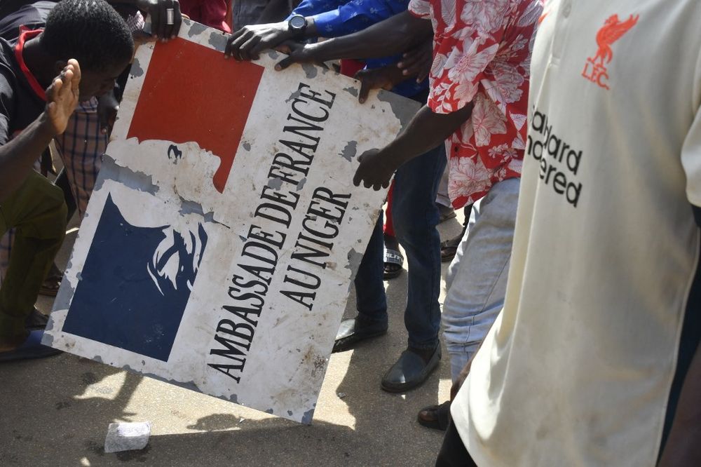 Protesters hold a sign taken from the French Embassy in Niamey during a demonstration that followed a rally in support of Niger's junta.