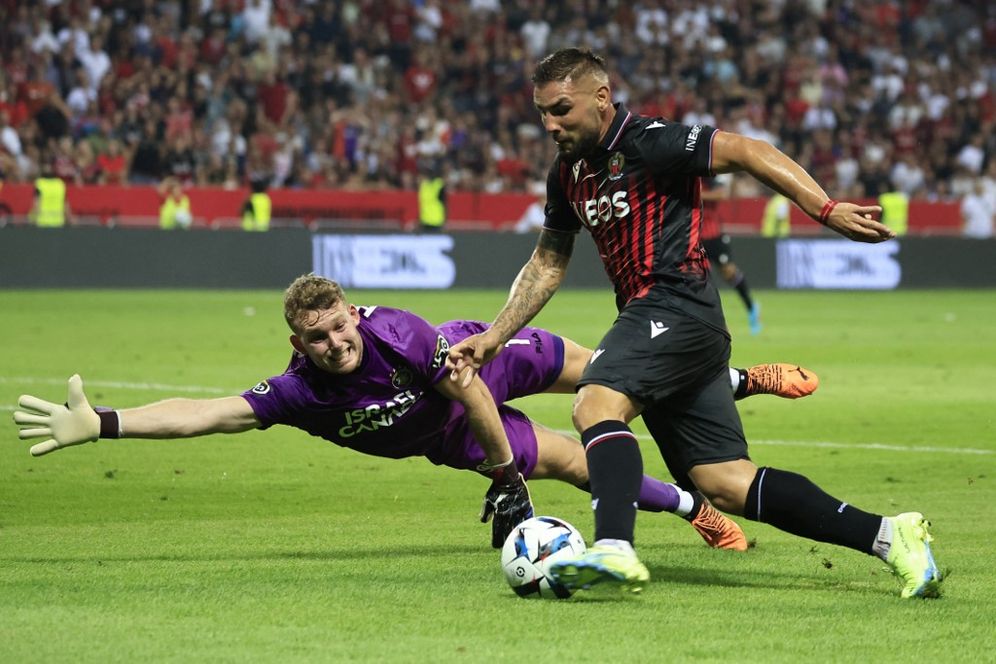 Nice's Algerian forward Andy Delort (R) fights for the ball with Maccabi Tel Aviv's Israeli goalkeeper Daniel Peretz during the UEFA Conference League.